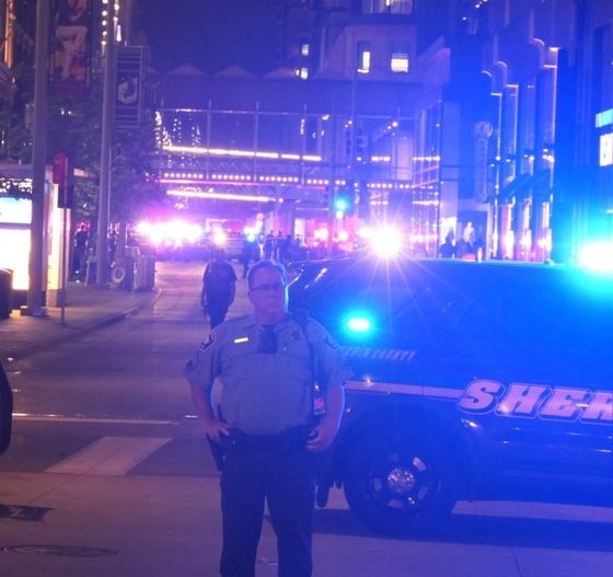 Police officer by sheriff SUV at night