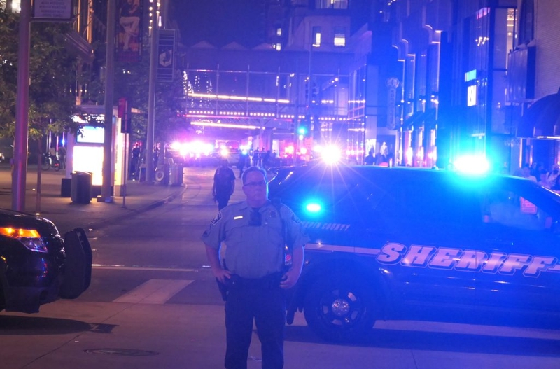 Police officer by sheriff SUV at night