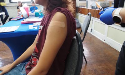 Child receiving vaccination with bandage on arm