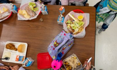 Children eating school lunch at cafeteria table