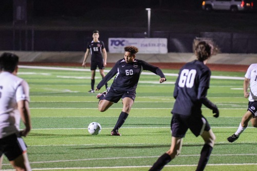 Soccer player kicking ball during nighttime match