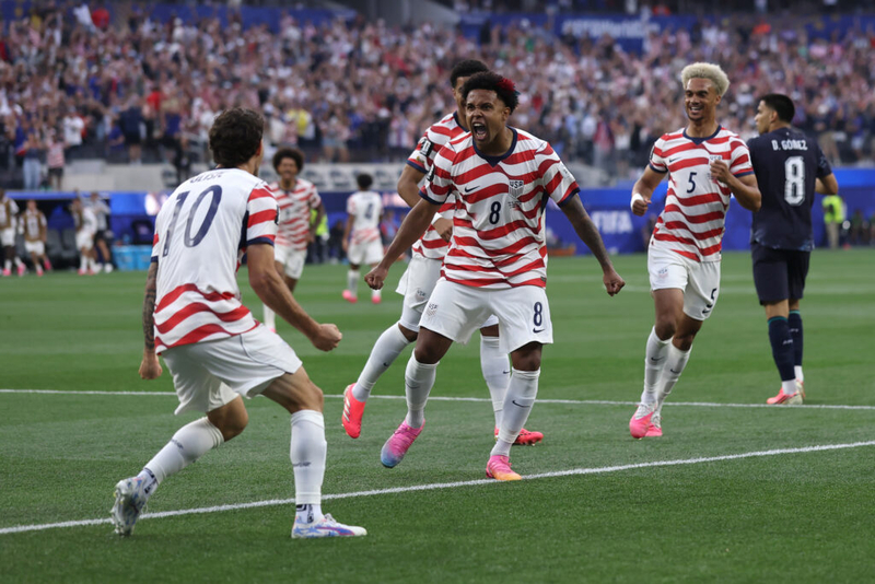 Soccer players celebrating goal in packed stadium