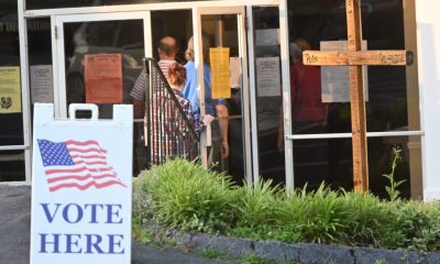 Voters entering polling place with Vote Here sign