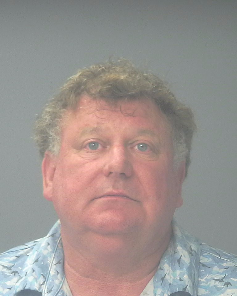 Man in patterned shirt against gray background