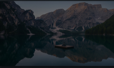 Person sitting on dock in mountain lake