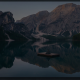 Person sitting on dock in mountain lake