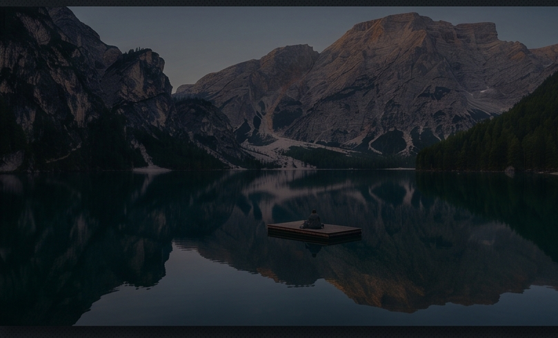 Person sitting on dock in mountain lake