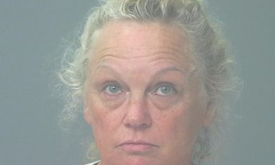 Woman in orange shirt facing camera against gray background