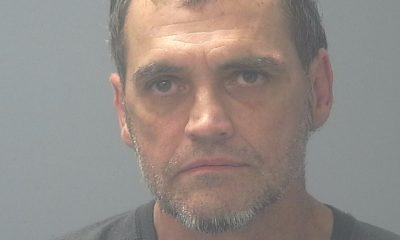 Portrait of a serious middle-aged man against gray background.