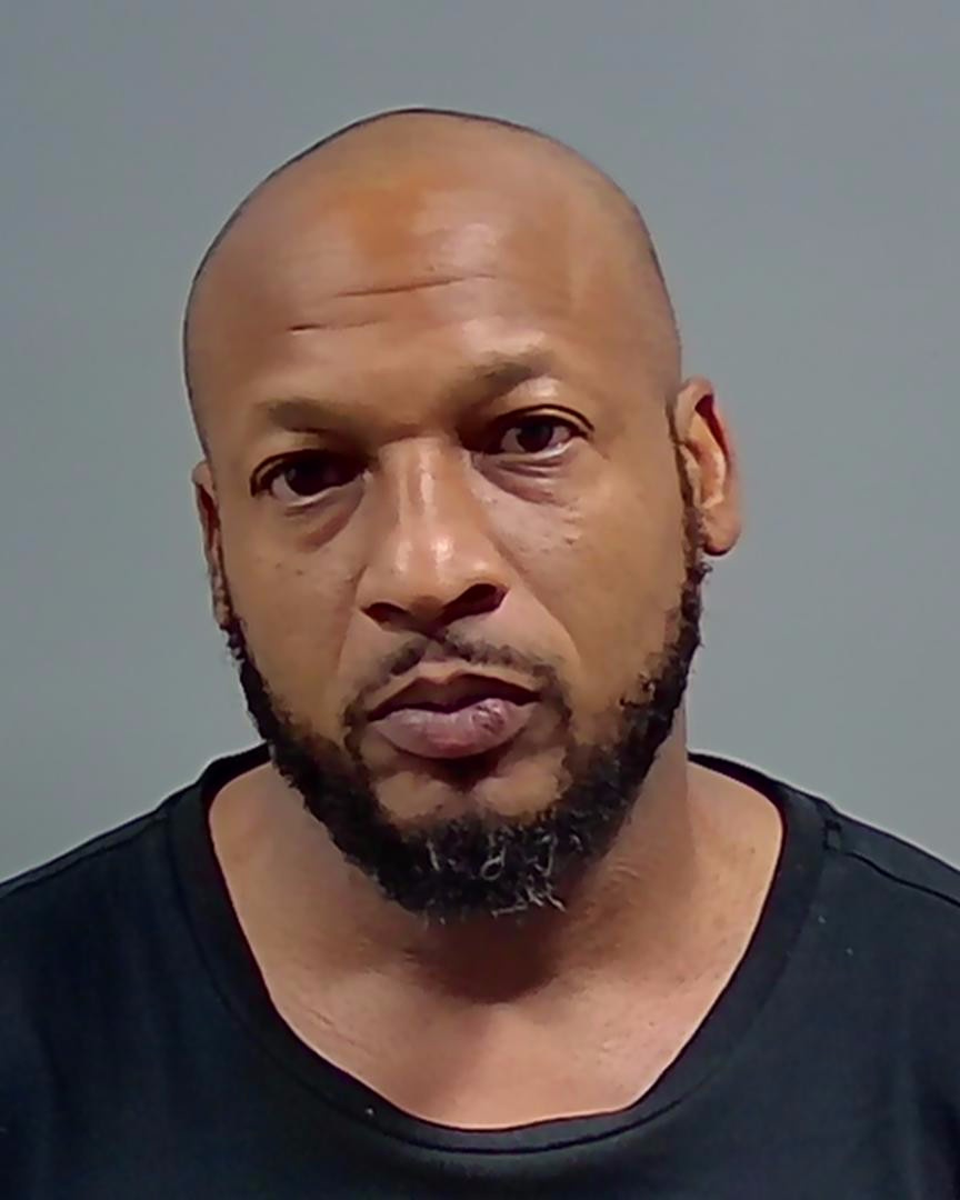 Bald man with beard in mugshot-style photo