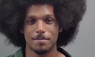Man with large afro hairstyle wearing green shirt