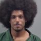 Man with large afro hairstyle wearing green shirt