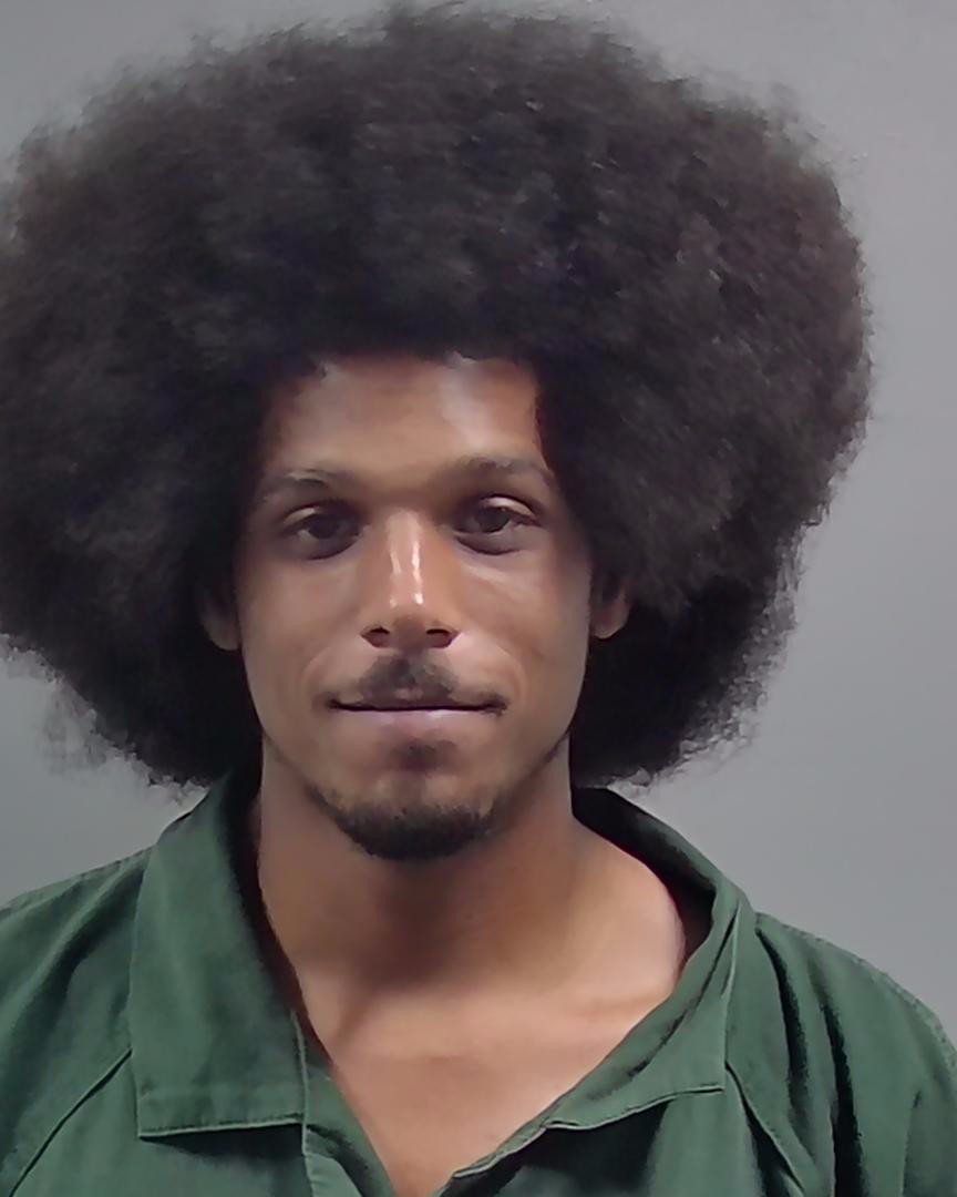 Man with large afro hairstyle wearing green shirt