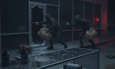 Two masked burglars flee through shattered storefront window
