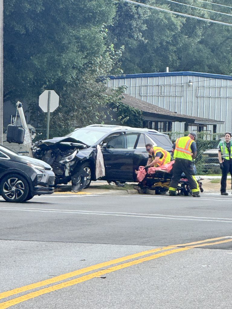 Emergency responders assist at a wrecked car after crash