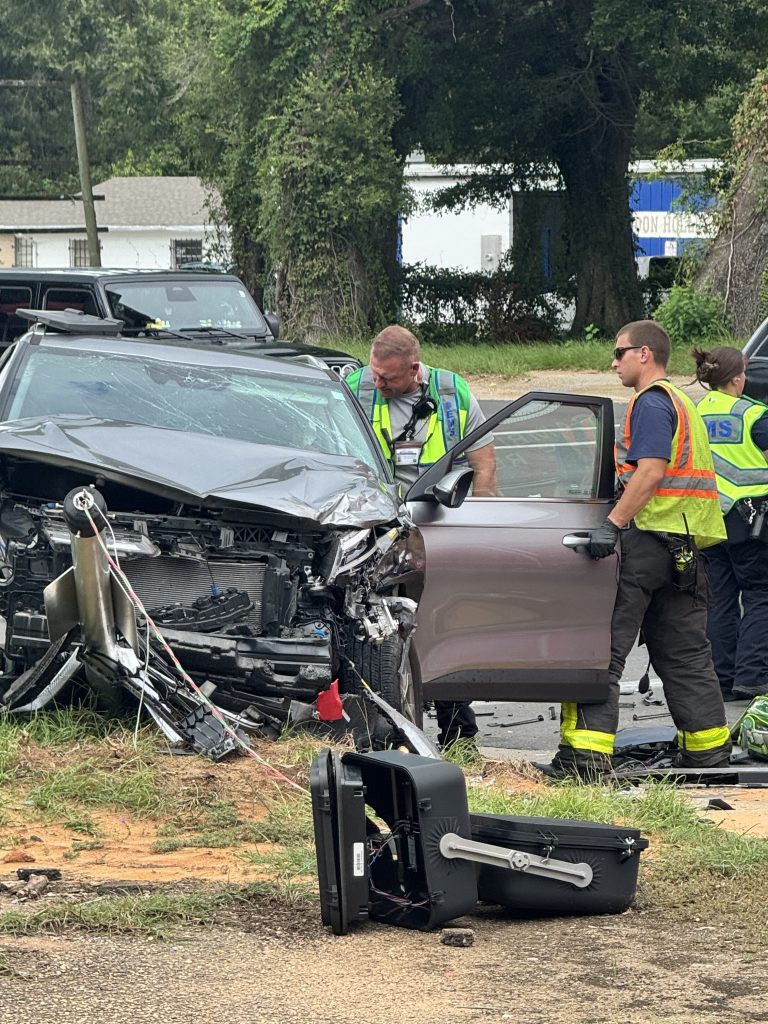 Emergency responders inspect severely damaged SUV after roadside crash.