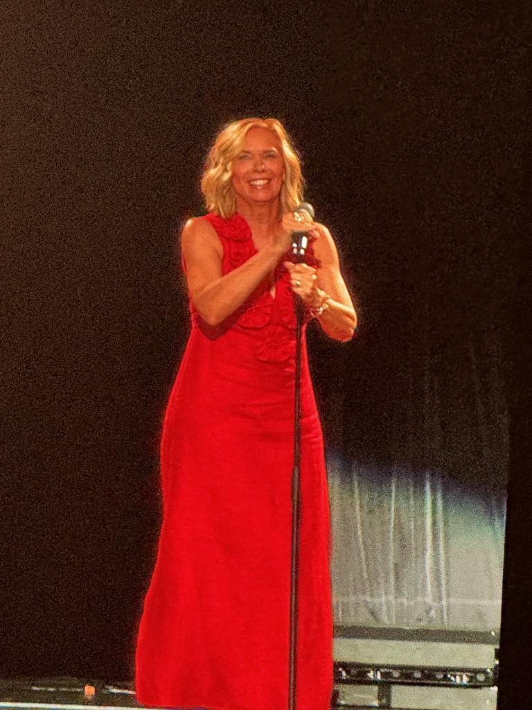 Woman in red dress speaks at podium