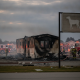 Severely damaged mobile home after a fire, with firefighters and emergency vehicles in the b — Cantonment Mobile Home Fire