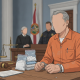 A man in an orange prison jumpsuit sits at a table with bags of drugs, facing a courtroom — tráfico de drogas en Florida
