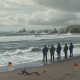 Group of people observing rough waves on a beach with warning flags, indicating dangerous — corrientes de resaca Escambia