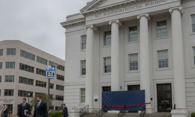 M.C. Blanchard Judicial Building with a large blue cover and a red ribbon, cloudy wea — Escambia County Courthouse Closure