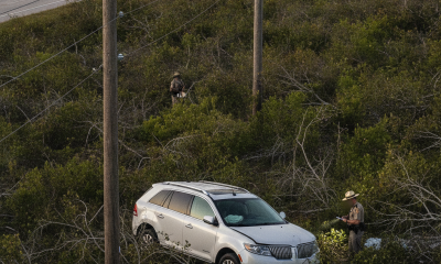A Lincoln MKX abandoned in a field after a crash near Highway 97, with emergency responders — Highway 97 Crash Walnut Hill