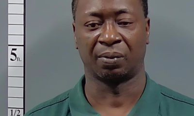 Man in green shirt posed beside height chart — Atmore shooting arrest