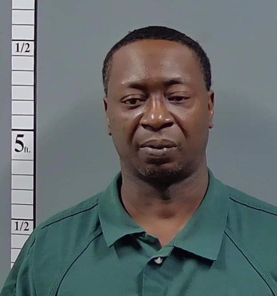 Man in green shirt posed beside height chart — Atmore shooting arrest