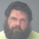 Mugshot-style portrait of a bearded man in yellow shirt — Jarod Christian Phelps hit and run