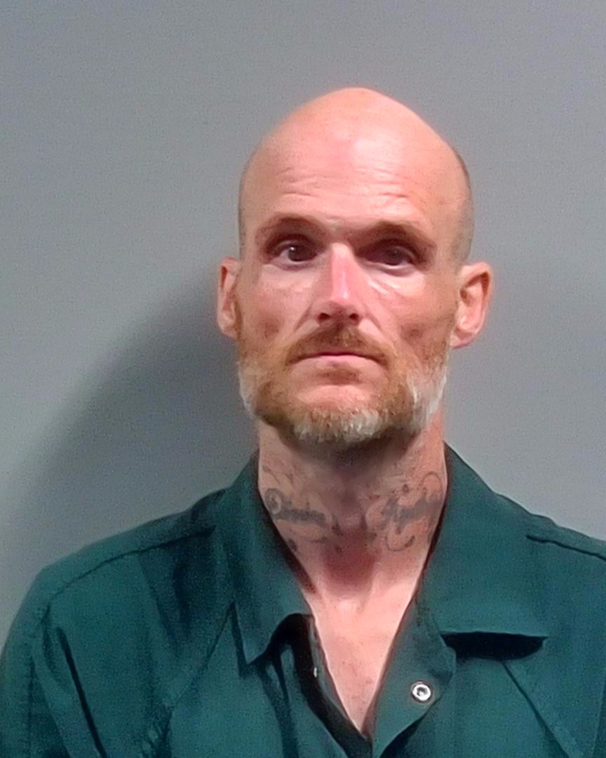 Mugshot of Daniel Eric Slayton, a bald man with facial tattoos, wearing a green prison unifor — Daniel Eric Slayton Arrest