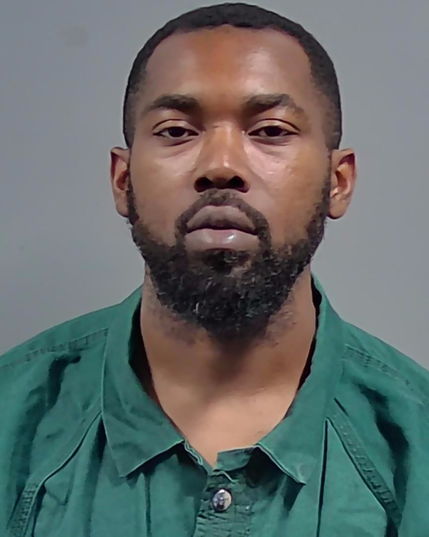 Mugshot of Arrington Marcellas Moultrie, showing a man with a beard and serious expression, wearing a green shirt.