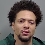 Close-up portrait of man with curly hair in green shirt — Cantonment Drug Bust