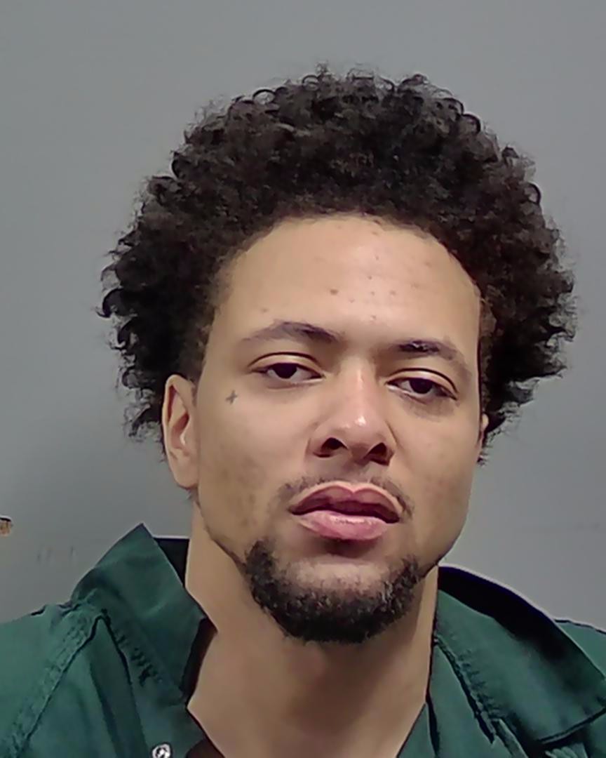 Close-up portrait of man with curly hair in green shirt — Cantonment Drug Bust