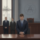 A man in a suit stands at a courtroom table with two men in suits behind him — Navarre man pleads guilty child pornography