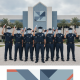 Nine Escambia County Corrections Officers in uniforms celebrate graduation outside the George Stone corrections academy.