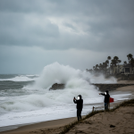 Personas observando olas grandes en una playa durante un aviso de oleaje alto en Escambia. — aviso de oleaje alto Escambia