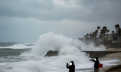 Personas observando olas grandes en una playa durante un aviso de oleaje alto en Escambia. — aviso de oleaje alto Escambia