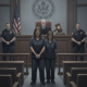 Two individuals in prison attire stand in a courtroom, flanked by police officers, with a judge — Timeka Griffin sentence