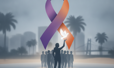 Silhouette of a person holding a dove with a large purple and orange ribbon — Domestic Violence Awareness Month Pensacola