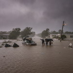 Residents wade through floodwaters during a severe storm in Escambia County, with damage — Escambia County Hurricane Watch