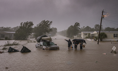 Residents wade through floodwaters during a severe storm in Escambia County, with damage — Escambia County Hurricane Watch