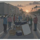 Group of people gathered around a table with food bags at sunset on a busy road, highlightin — Meals That Matter Pensacola