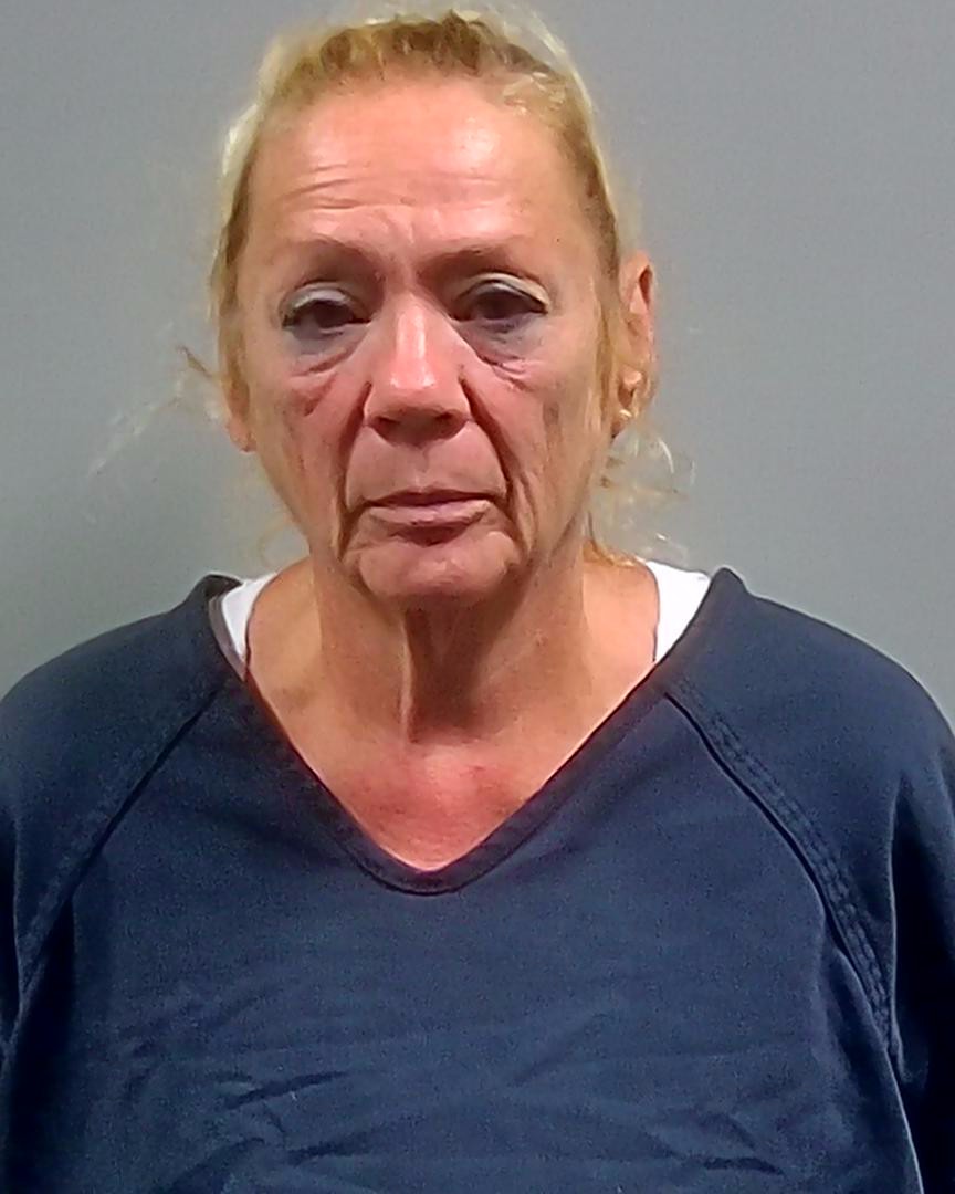 Mugshot of Susanna Marianna Wright, a woman with blonde hair, wearing a blue prison shirt, looking serious.