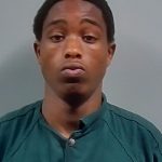 Booking photo of Deangelo Jerrell Bolden, a young man with short hair wearing a green shirt, looking serious.