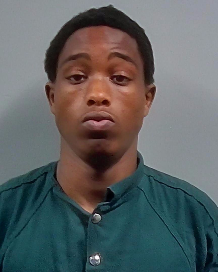 Booking photo of Deangelo Jerrell Bolden, a young man with short hair wearing a green shirt, looking serious.
