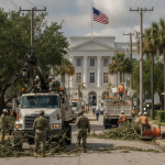 Workers and Florida National Guard personnel clear storm debris from a street in Pensacola, wit — Pensacola Storm Recovery