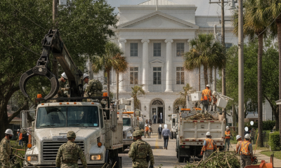Workers and Florida National Guard personnel clear storm debris from a street in Pensacola, wit — Pensacola Storm Recovery