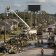 Workers and heavy machinery clear debris from a street in Pensacola after Hurricane Isaias, — Pensacola hurricane recovery