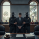 A man in a suit is escorted by two law enforcement officers in a courtroom settin — Roosevelt Allen Douglas II guilty plea