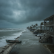 Coastal scene in Escambia during storm surge watch, with rough seas, dark clouds, and a boat — Pensacola storm surge watch